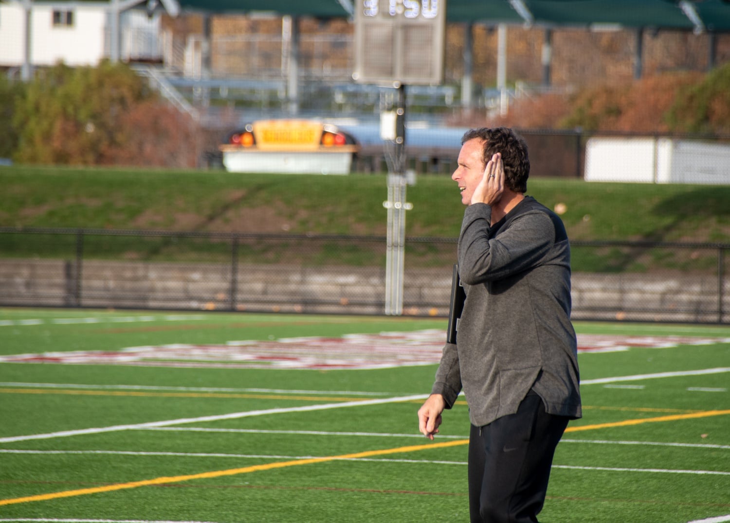 Head coach Christopher Hamblin listens as he communicates from the sideline in the first half.