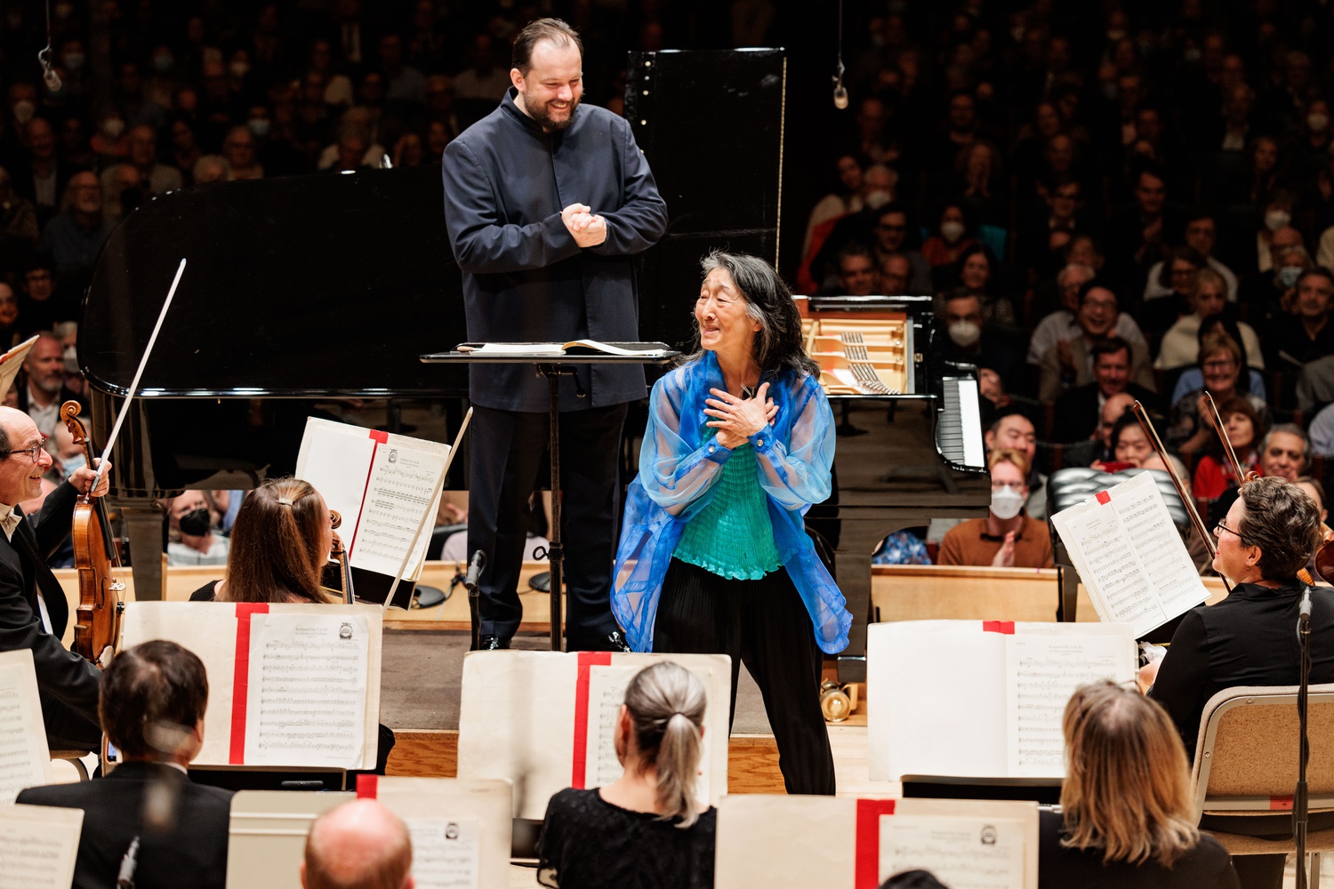 Pianist Mitsuko Uchida receives an ovation while Andris Nelsons and the Boston Symphony Orchestra look on.
