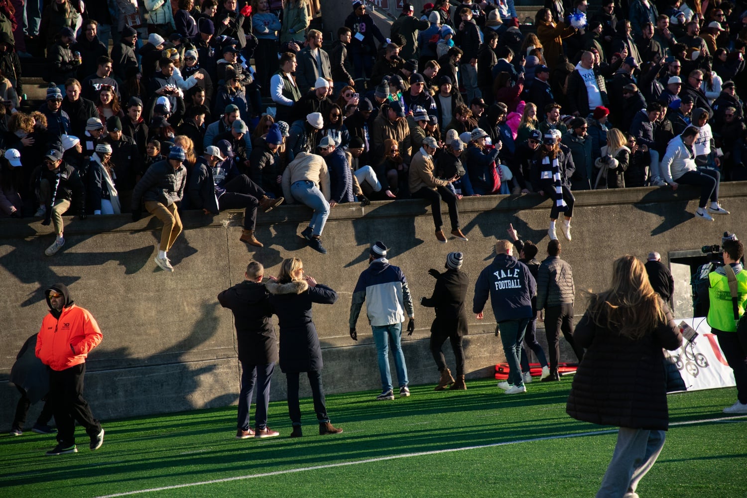 Yale fans leap over the walls onto the field at Harvard Stadium. After crimson-clad supporters flooded the field at the Yale Bowl after last year's incredible victory, Bulldogs fans returned the favor on Saturday.