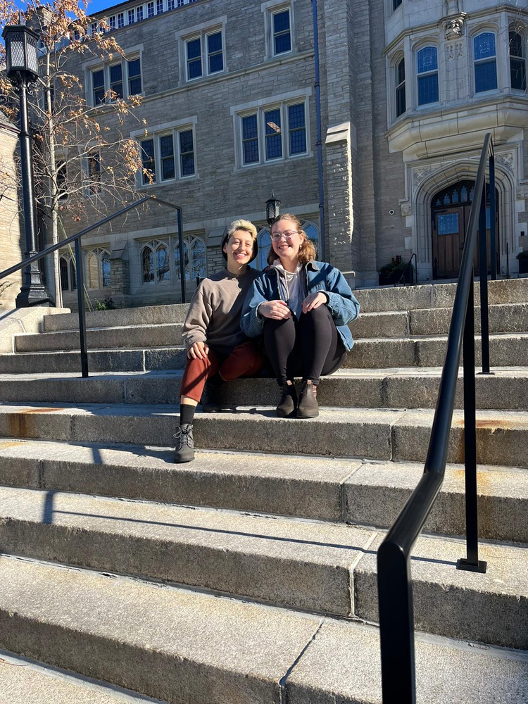 Jews for Liberation members S. Lovett-Graff and Francesca Rubinson sitting outside Harvard Divinity School.