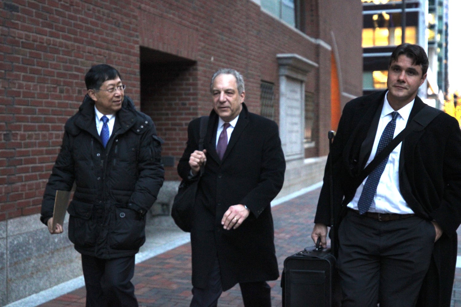 Jie “Jack” Zhao, left, exits the John Joseph Moakley United States Courthouse alongside members of his defense team on Monday. Zhao and former Harvard fencing coach Peter Brand are on trial facing bribery charges.