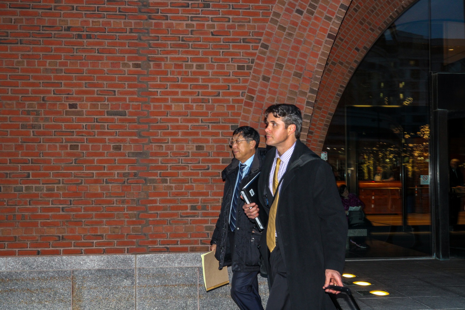Jie “Jack” Zhao, left, leaves the John Joseph Moakley United States Courthouse alongside his attorney, Michael Packard '02.