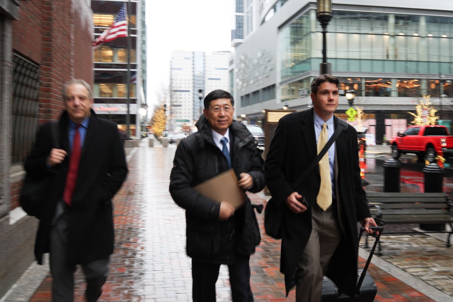 Jie "Jack" Zhao, center, and his attorneys, William D. Wenreb, left, and Michael T. C. Packard '02, right, exit the John Joseph Moakley United States Courthouse in Boston.