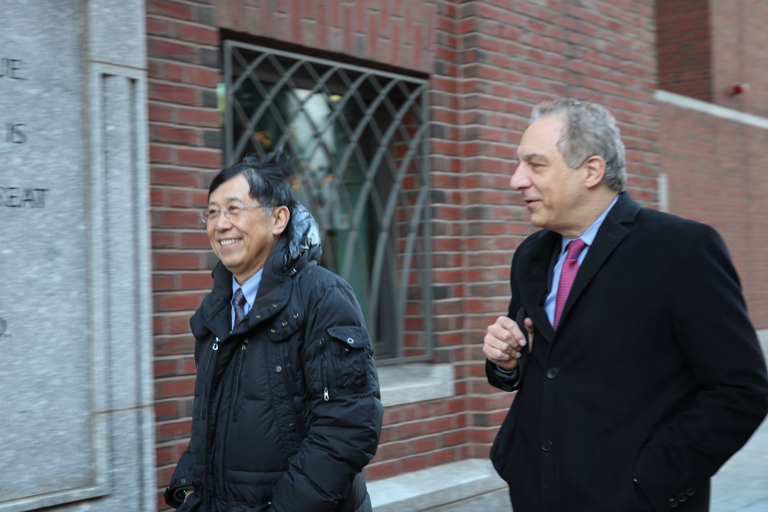 Jie "Jack" Zhao, left, exits the John Joseph Moakley United States Courthouse in Boston alongside his attorney, William D. Weinreb.