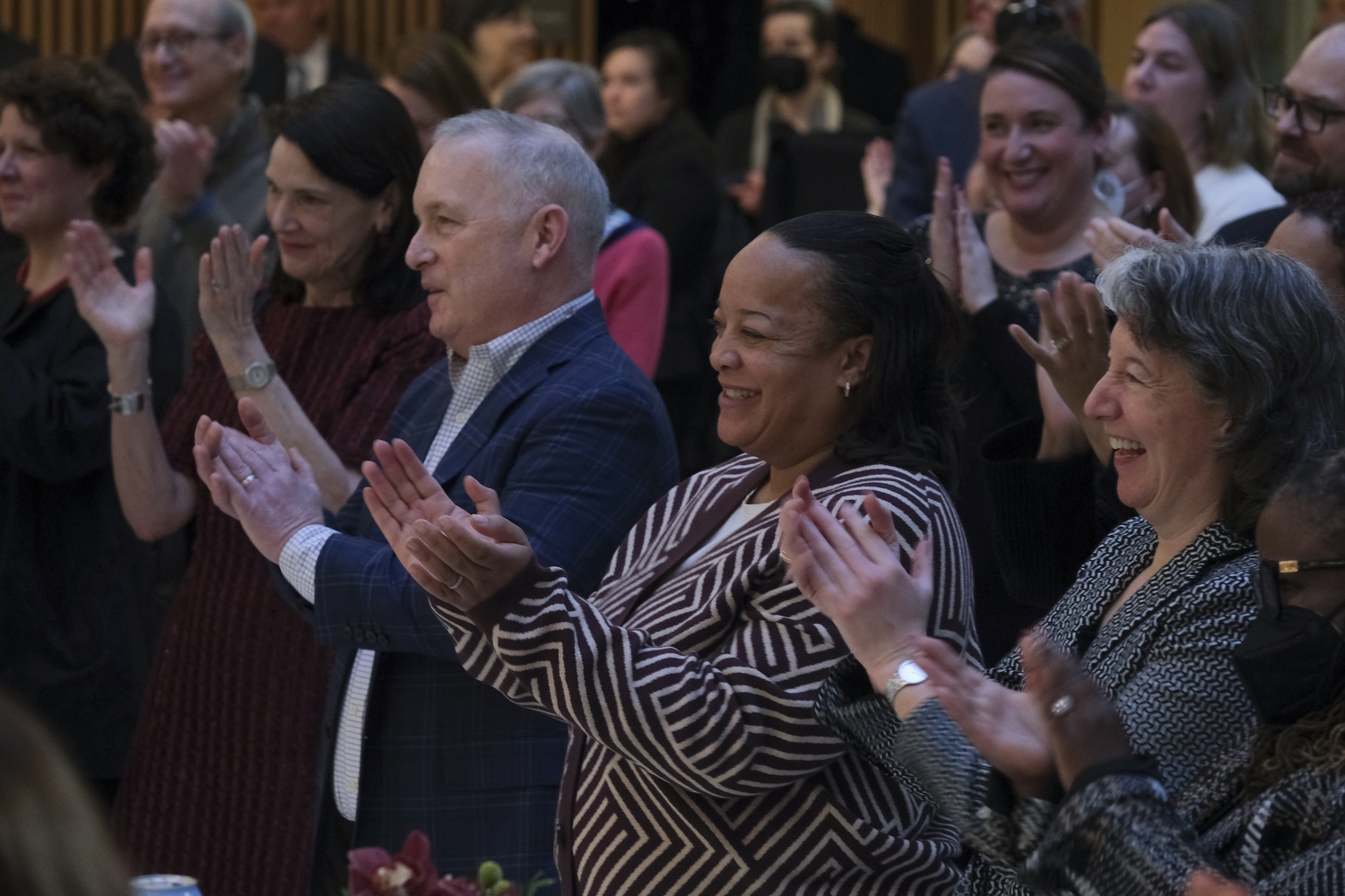 Harvard Graduate School of Education Dean Bridget T. Long, center, and other audience members cheer as Dean of the Faculty Claudine Gay is announced as Harvard's next president.