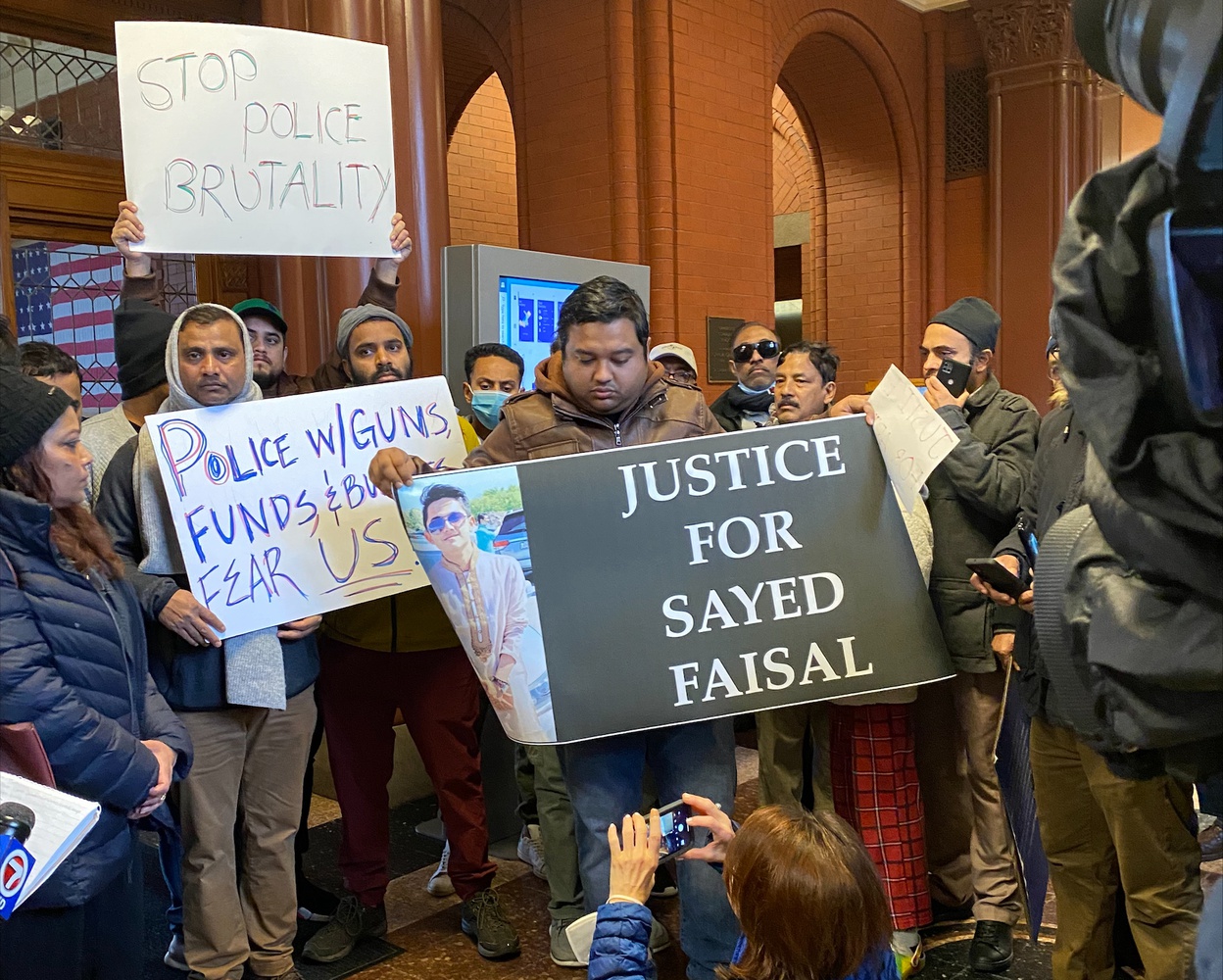 Dozens gathered at Cambridge City Hall Thursday afternoon to protest a Cambridge police officer's killing of University of Massachusetts Boston student Sayed Faisal.