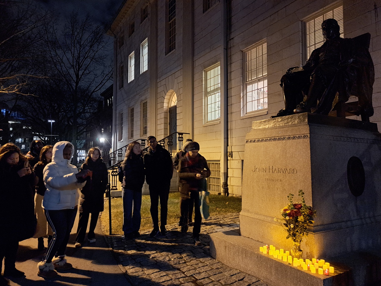 Harvard affiliates gathered in front of University Hall Thursday evening for a vigil to honor the victims of three shootings in California in the last week.