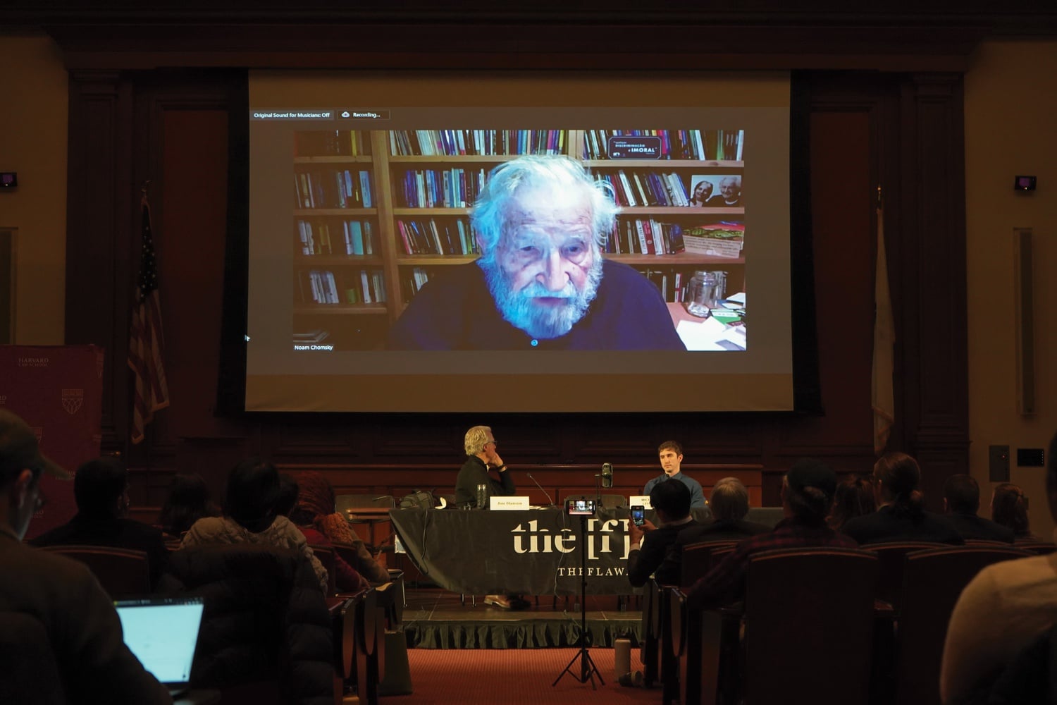 MIT Emeritus Professor Noam Chomsky begins speaking as fellow panelist Professor Jon Hanson looks on. The two spoke at Harvard Law School's conference on corporate capture of the legal system in January 2023.