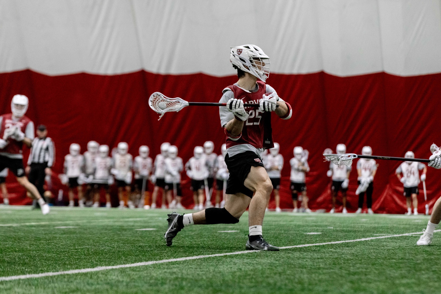 Junior midfield Mark Stephens moves up the field with the ball in the team's first internal scrimmage of the season. In 2022, Stephens scored a goal in a February 19 game against NJIT, which was Harvard's first game since the Covid-19 pandemic.
