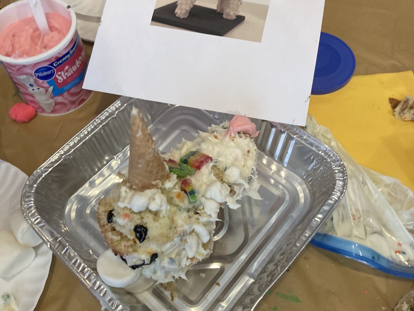 An attempt to recreate a reference photo unicorn cake, visible in the middle picture, during the final round of event.