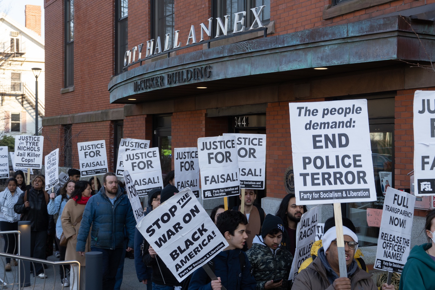 Protesters rallied on the steps of the City Hall Annex, waving signs and calling for justice following the police killing of Sayed Faisal.