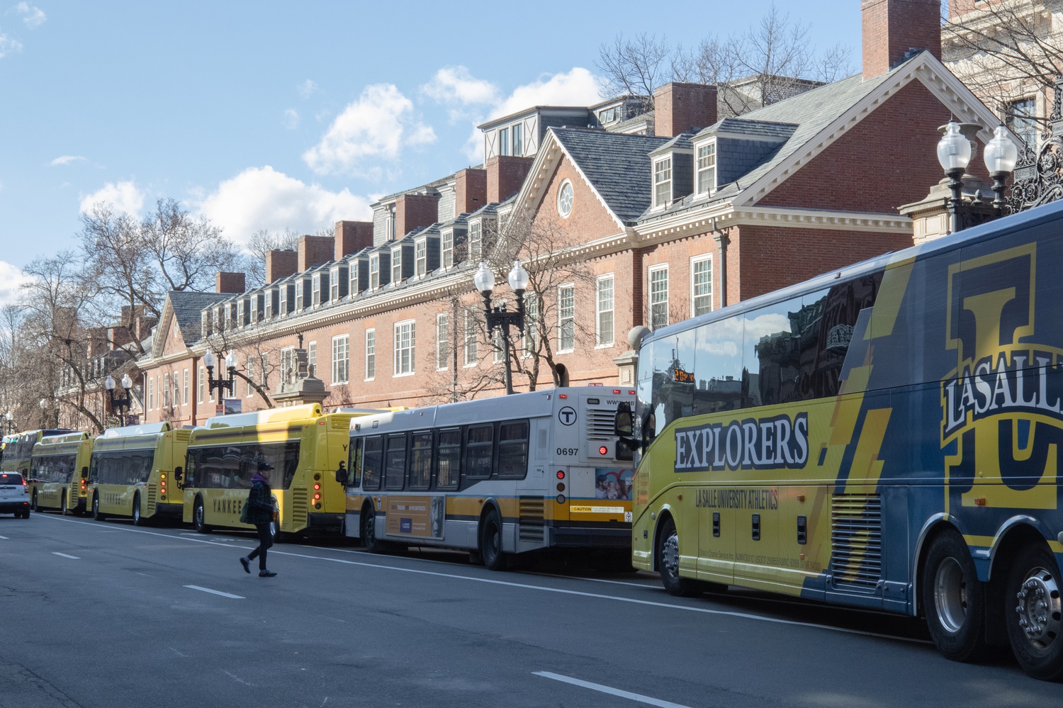 Shuttle buses line Massachusetts Avenue outside Wigglesworth Hall to carry Red Line riders inbound as service was disrupted for signal work over the weekend.