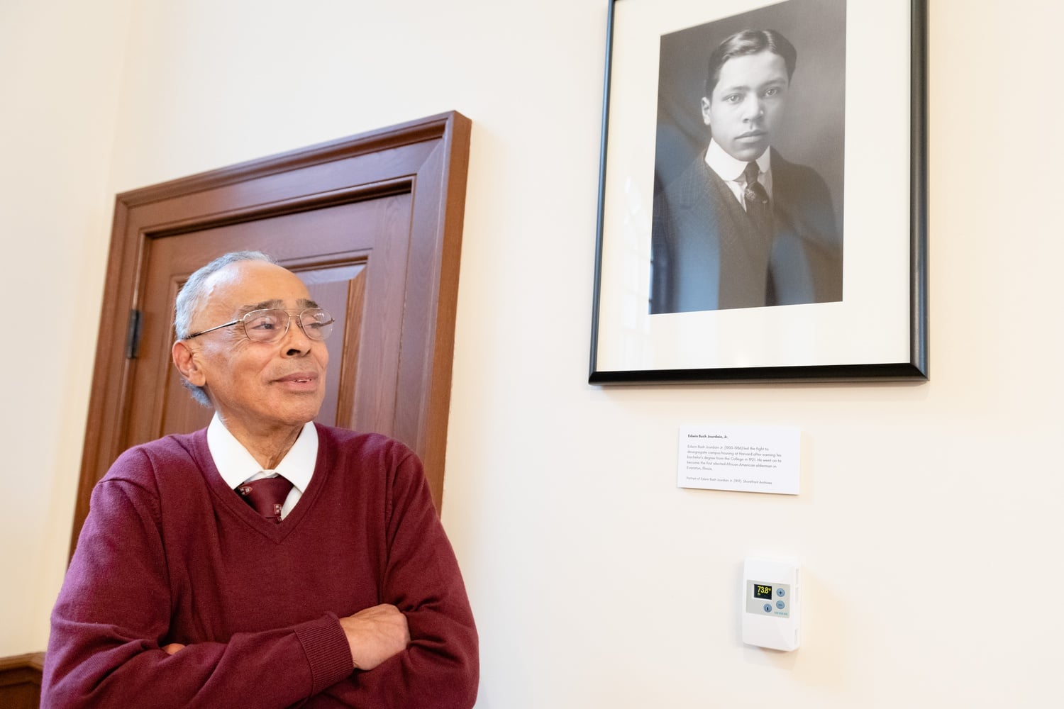 Spencer C.D. Jourdain '61 stands in front of a newly unveiled portrait of his father, Edwin Bush Jourdain Jr., at a ceremony in Winthrop House's Senior Common Room on March 31.