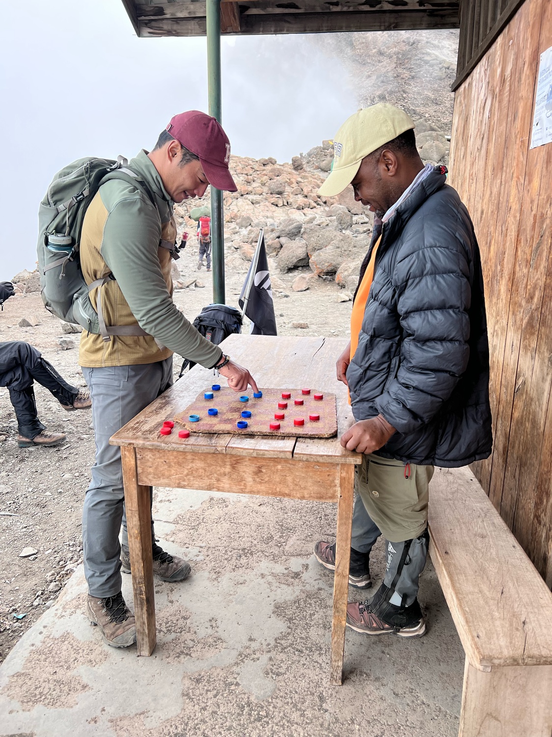 Nick playing checkers with his guide, Eli, on the slopes of Mount Kilimanjaro.