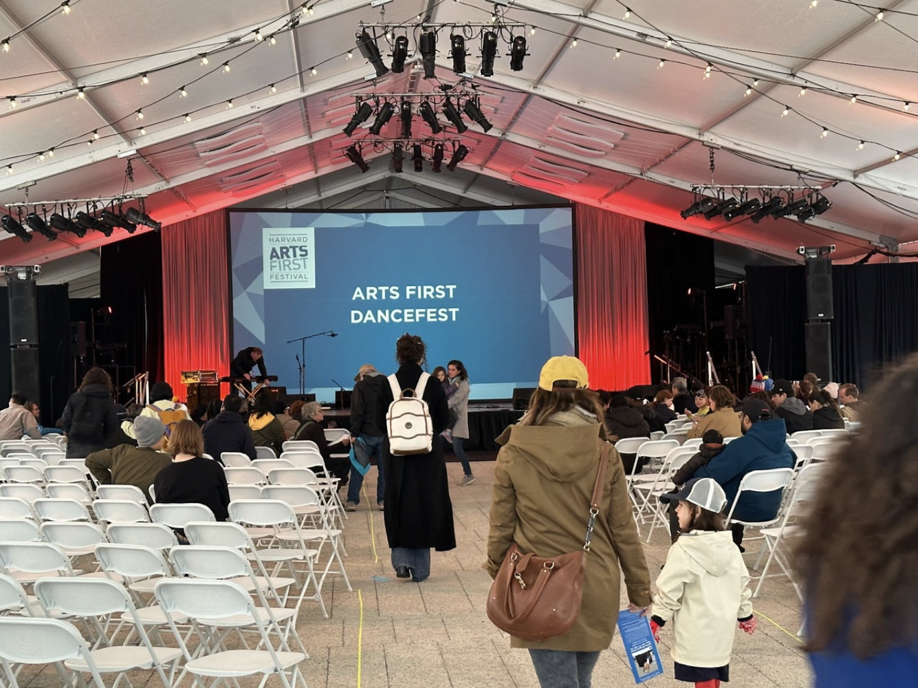 The local community preparing to watch an ARTS FIRST performance in the Plaza Tent in front of the Science Center.