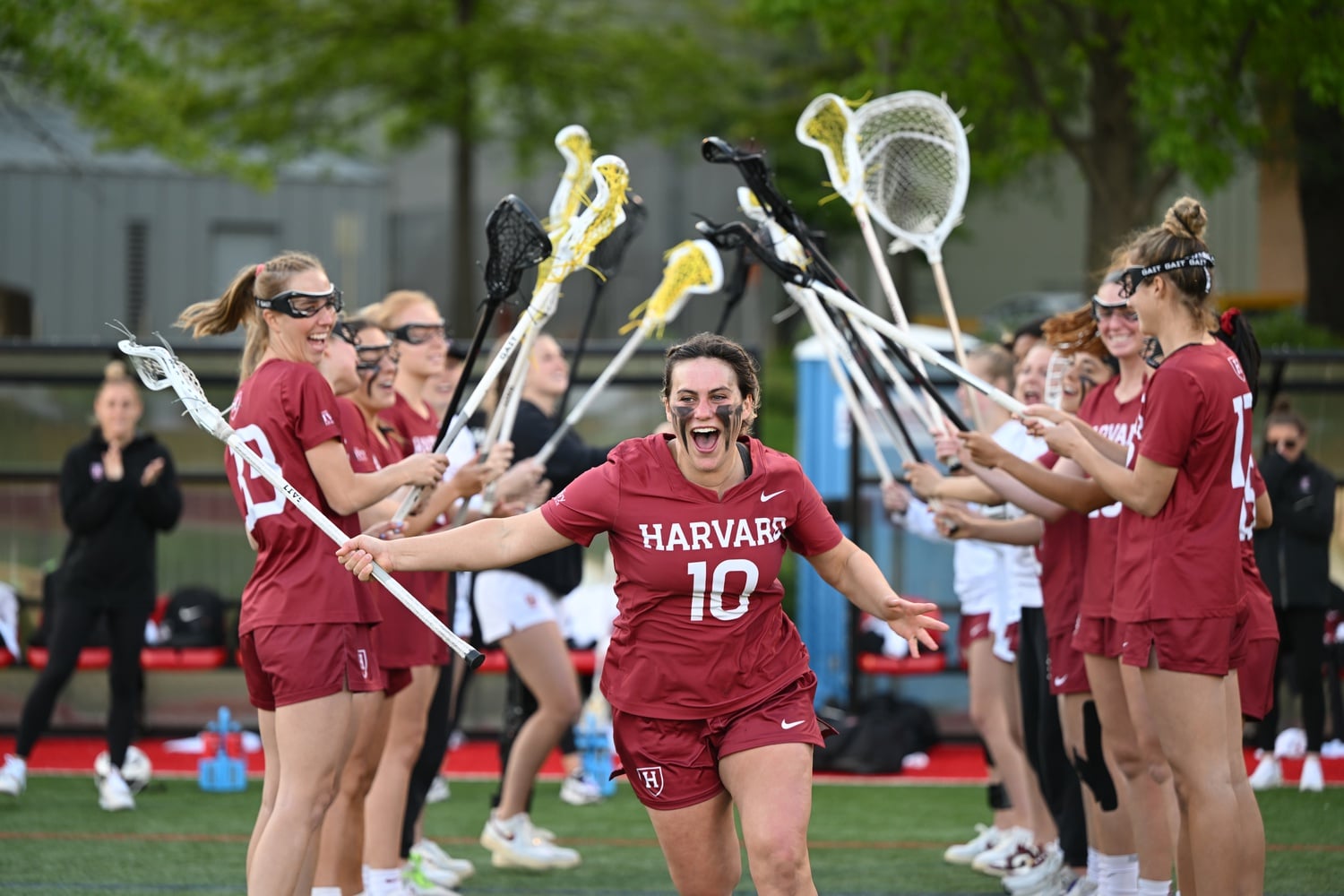 Sophomore defender Grace Taylor runs through her teammates in a huddle at one of Harvard women's lacrosse's spring games.