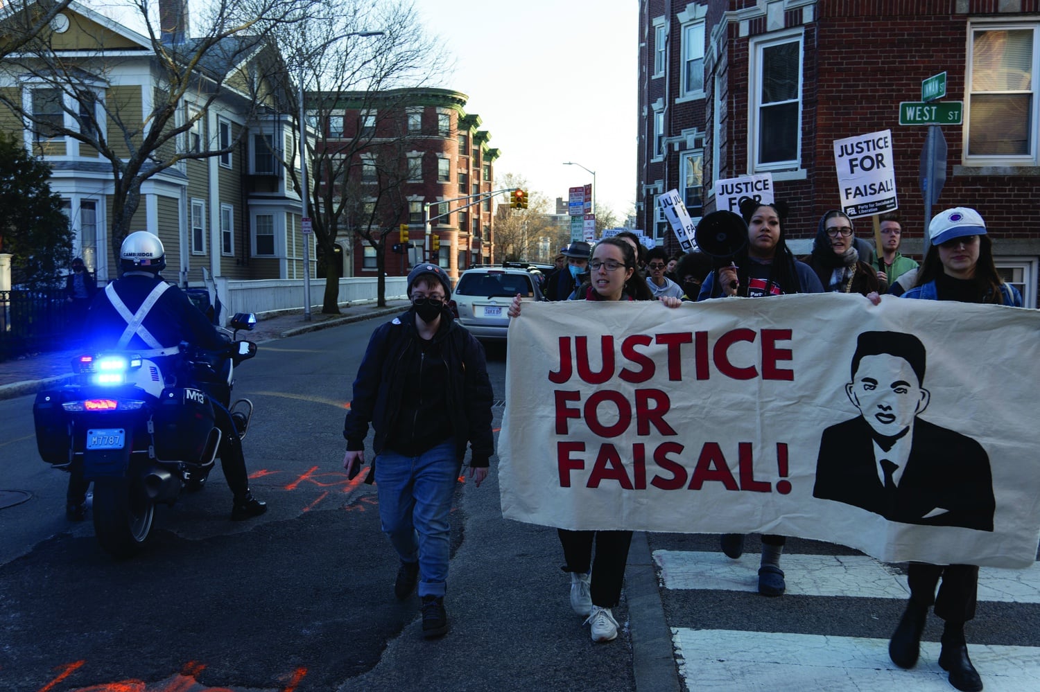 Protesters rally on the steps of the City Hall Annex earlier this year, waving signs and calling for justice following the police killing of Sayed Faisal.