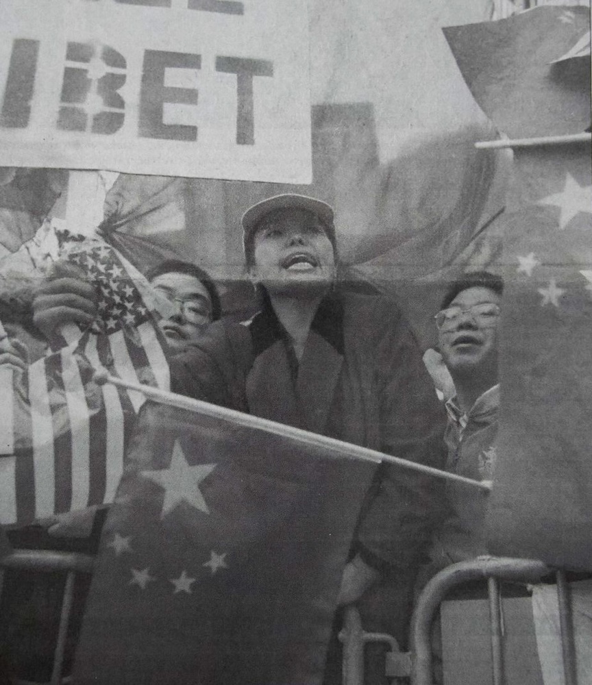 Protesters waving U.S. and Chinese flags flanked both sides of Jiang's pathway to Sanders Theatre.