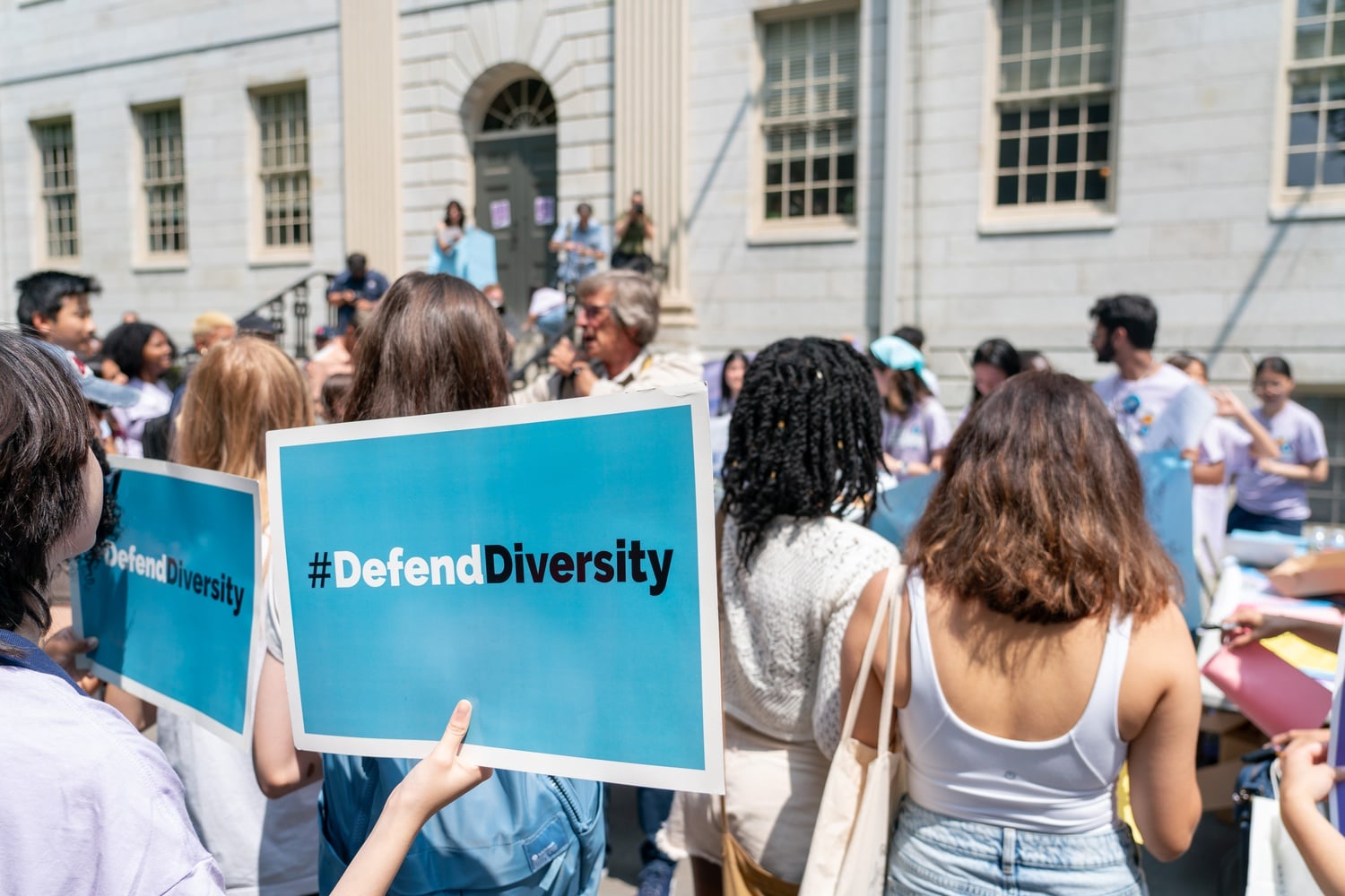 A demonstrator holds up a sign with the slogan #DefendDiversity in front of University Hall at a rally following the 2023 Supreme Court ruling on affirmative action.