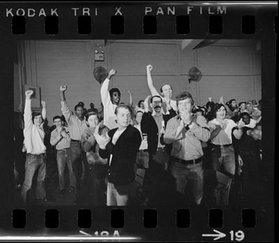 Cover image for Men raise their fists during a 1971 rally for better conditions in Walpole Prison.