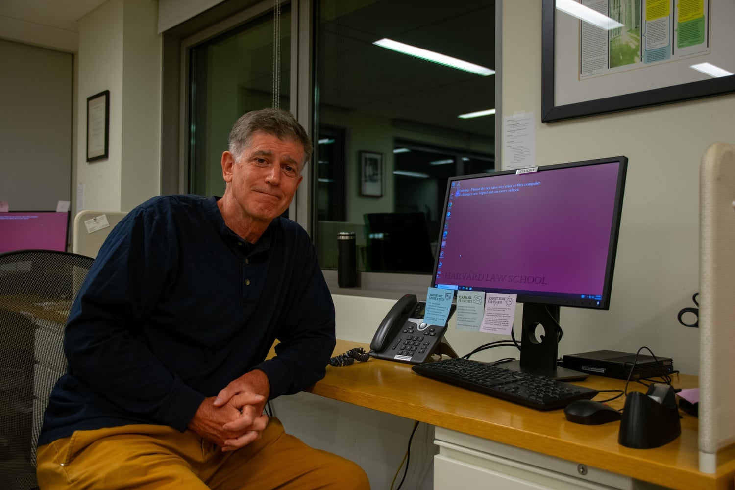 John D. Fitzpatrick sits at a desk where students receive calls from prisoners in the PLAP office. Fitzpatrick worked at PLAP as a student in the 80s and has been a clinical instructor there for the past 25 years.