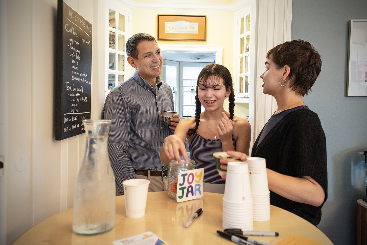 Matthew Ichihashi Potts, left, his daughter Cami, center, and Harvard Divinity School student Elizabeth S. Propst ’23 gather at a weekly After School Snack hosted by Potts and his family.