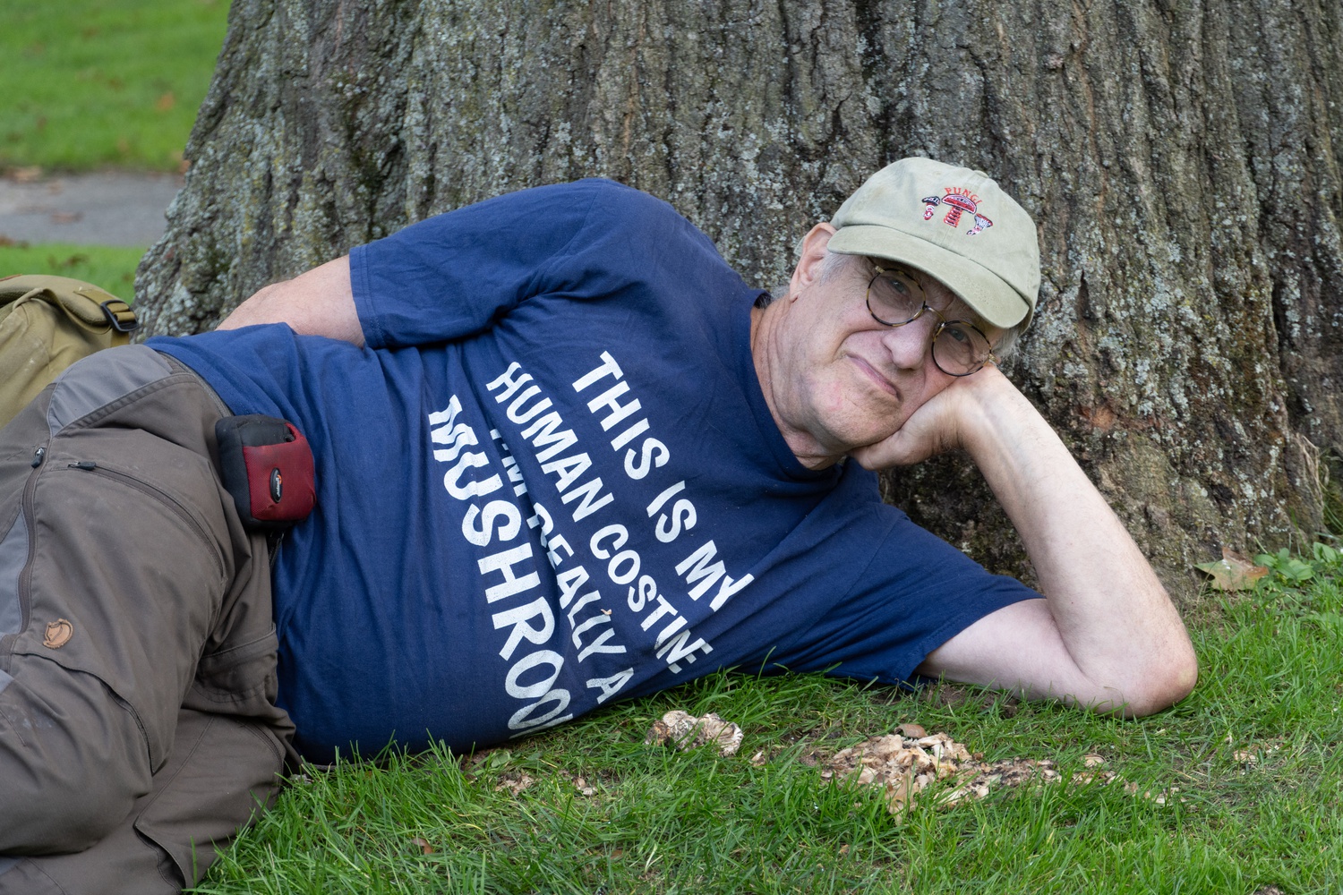 Millman posing behind a cluster of wild mushrooms on campus.