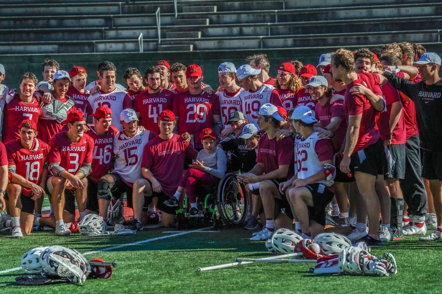 The Harvard men's lacrosse team poses with Braxton, its Team IMPACT teammate, after the team's Burrito Bowl event on October 21, 2023.