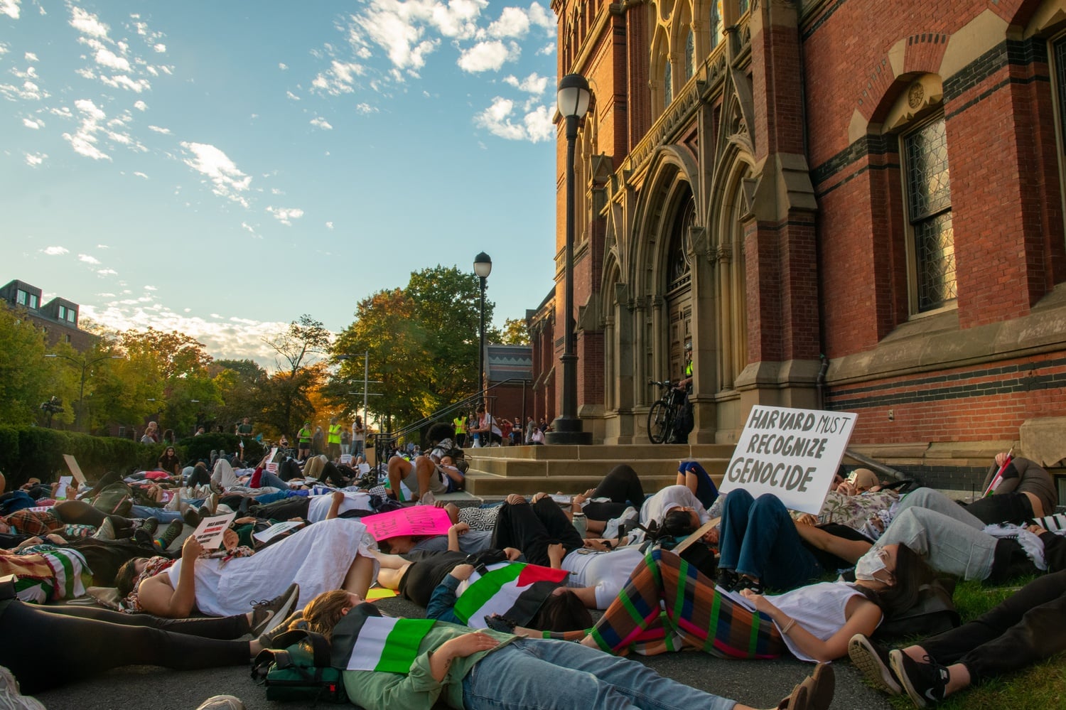Students hold a “die-in” protest in front of Memorial Hall as students’ family members in attendance for Family Weekend watch on.