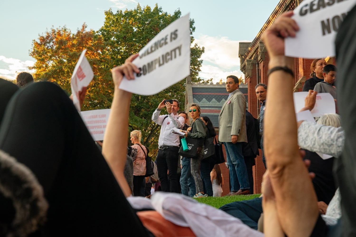 Parents attending Family Weekend watch as pro-Palestinian protesters stage a die-in in front of Memorial Hall.
