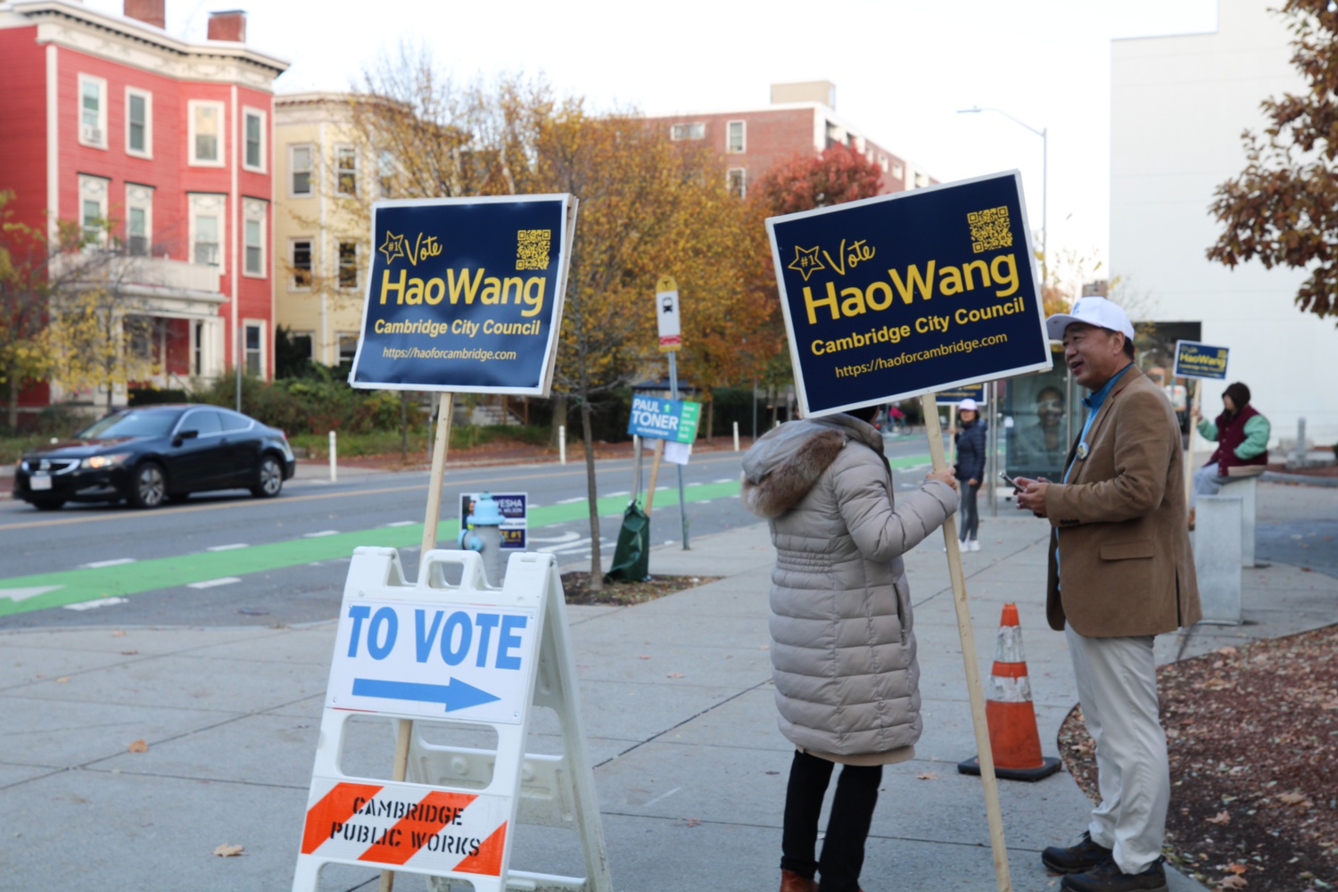 Challenger Hao Wang talks to a voter outside the Cambridge Rindge and Latin polling site on election day.