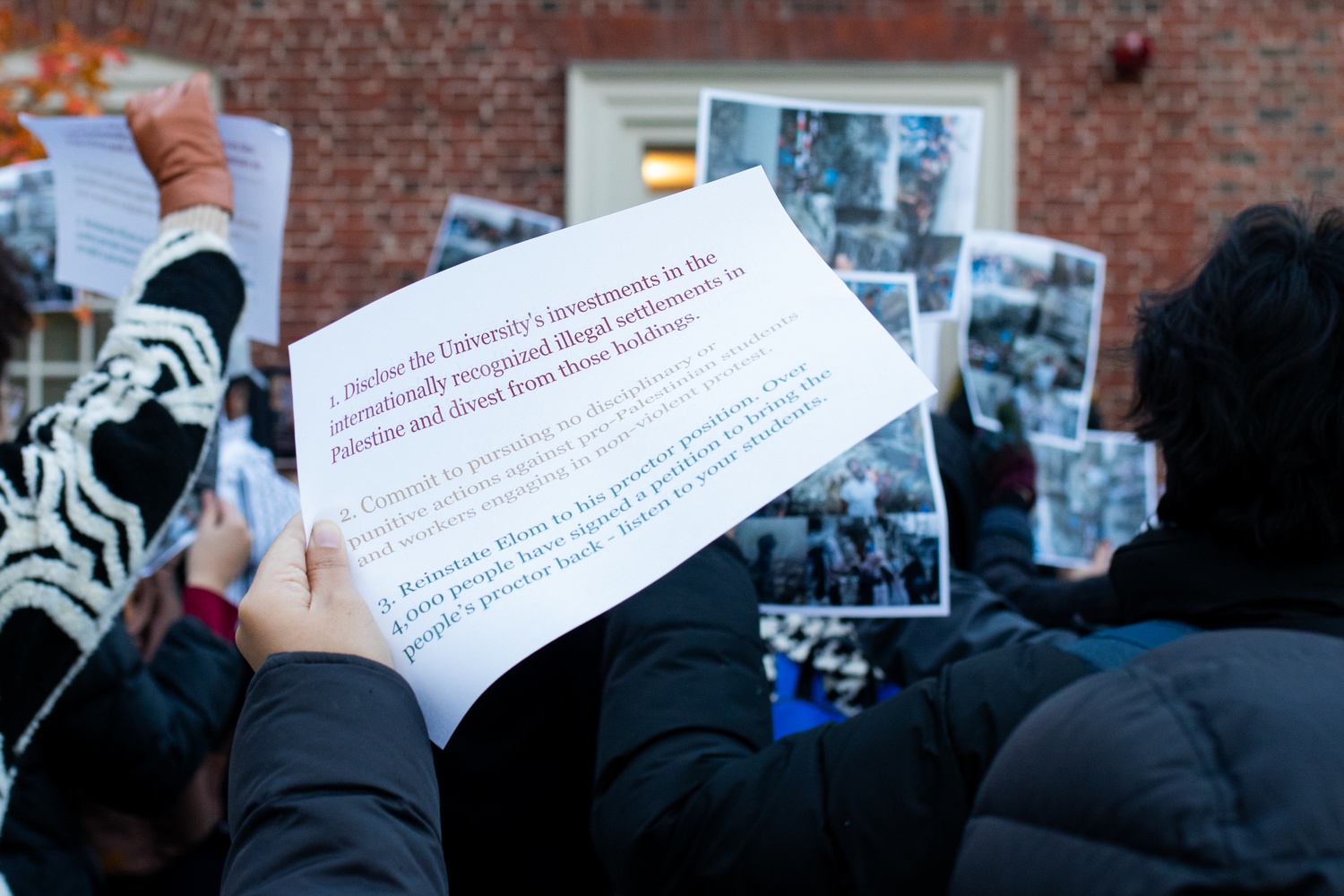 Protesters brandish leaflets outlining their demands, including a call for the University to disclose and divest from any holdings in Israeli settlements that many international organizations deem illegal.