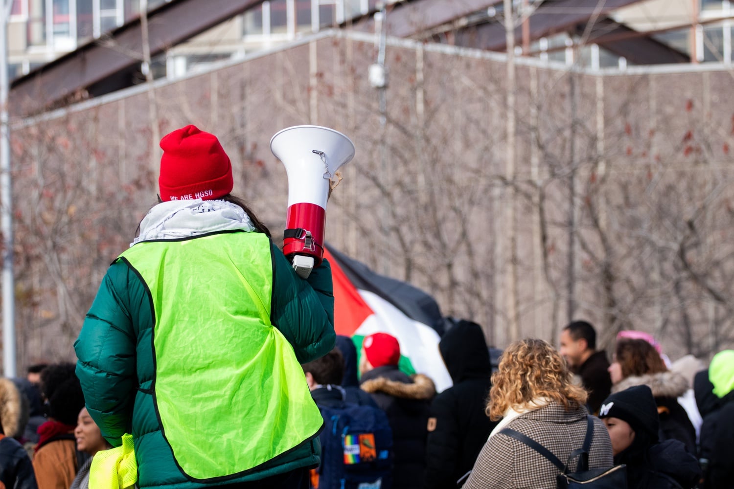 An HGSU-UAW member holds a megaphone at a rally in Science Center Plaza last Wednesday co-organized by Harvard BDS.