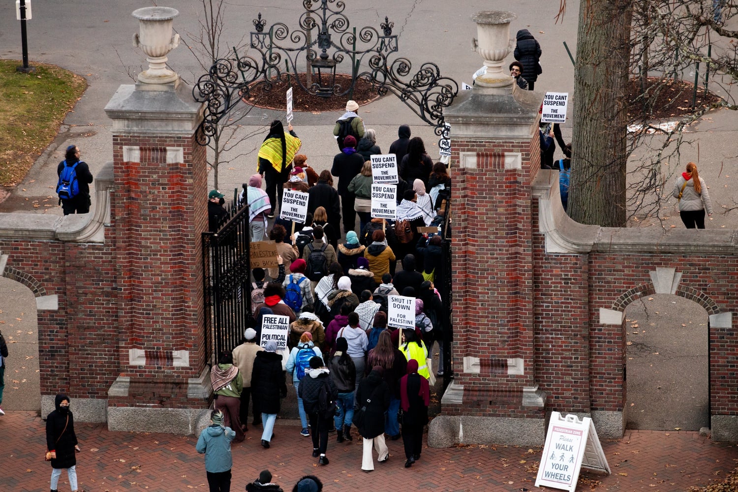 Rallygoers march to Mass. Hall from the Science Center Plaza on Monday. Throughout the week of action, speakers criticized Gay for what they described as a lack of adequate support for Muslim and Palestinian students.