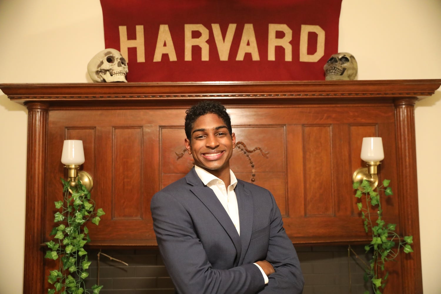 In Arjun's dorm is a nook with three red armchairs, a faux taxidermy deer mount, and a wall covered with a wood-patterned wallpaper to “emulate the old Harvard aesthetic,” he explains.