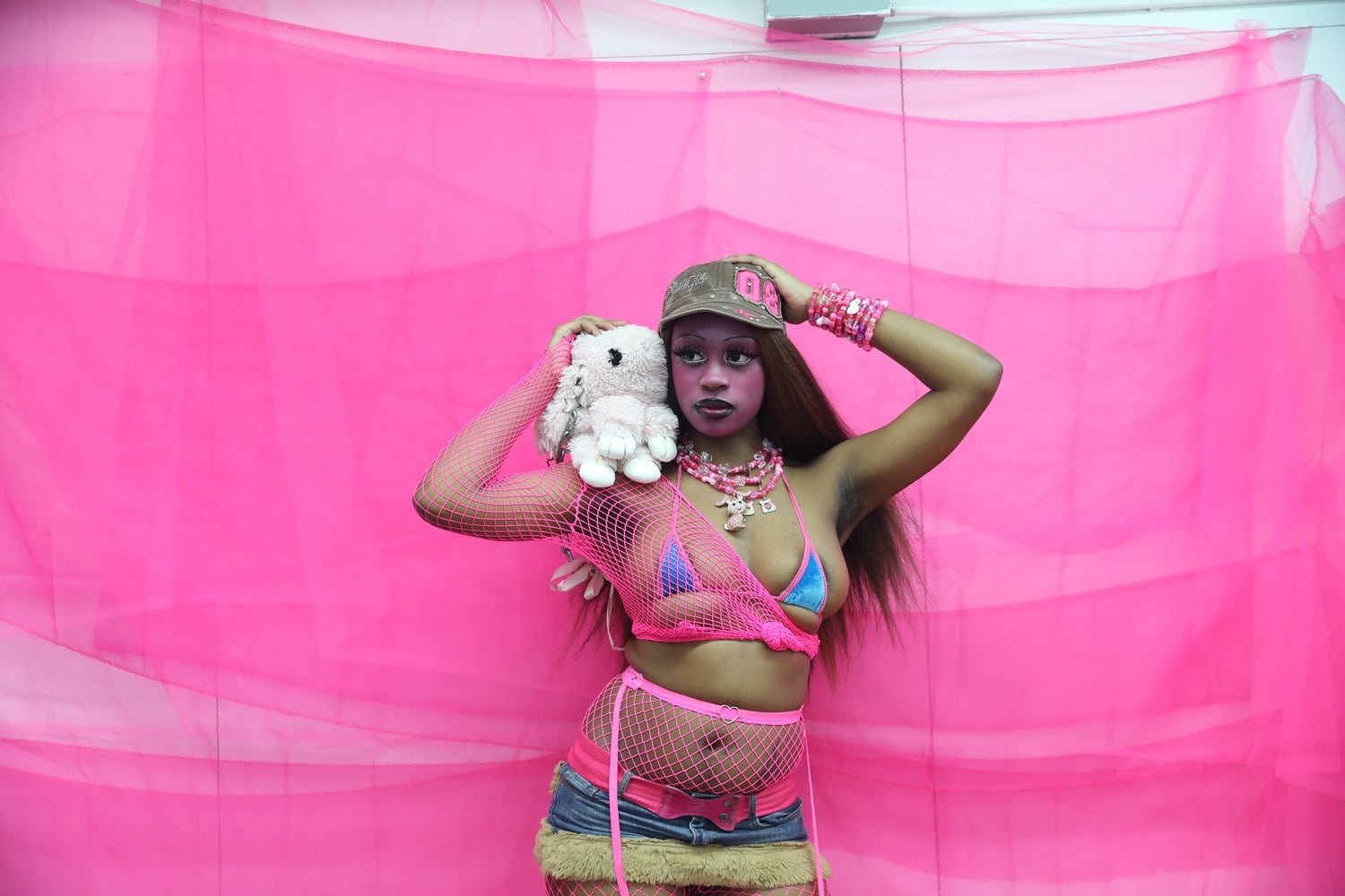 Allure transforms pink — a typically soft, demure, “girly” shade — into a color with teeth. They are a nonbinary femme lesbian, and they remix the rules of femininity in order to represent their identity.