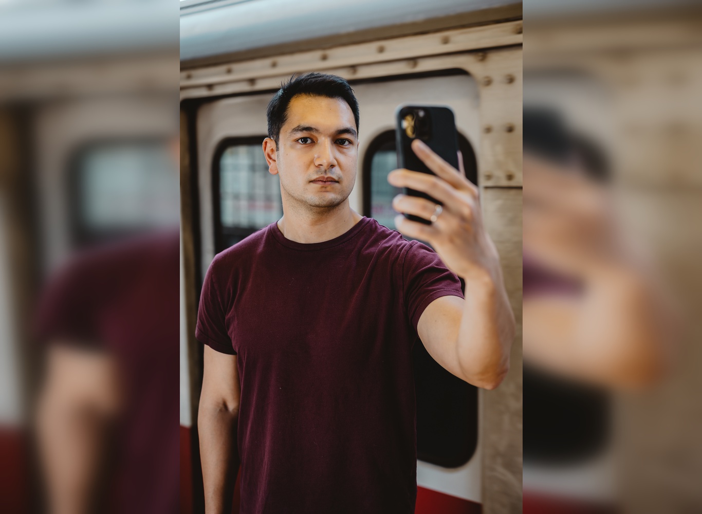 Headshot photo of Jed Paul holding his phone.