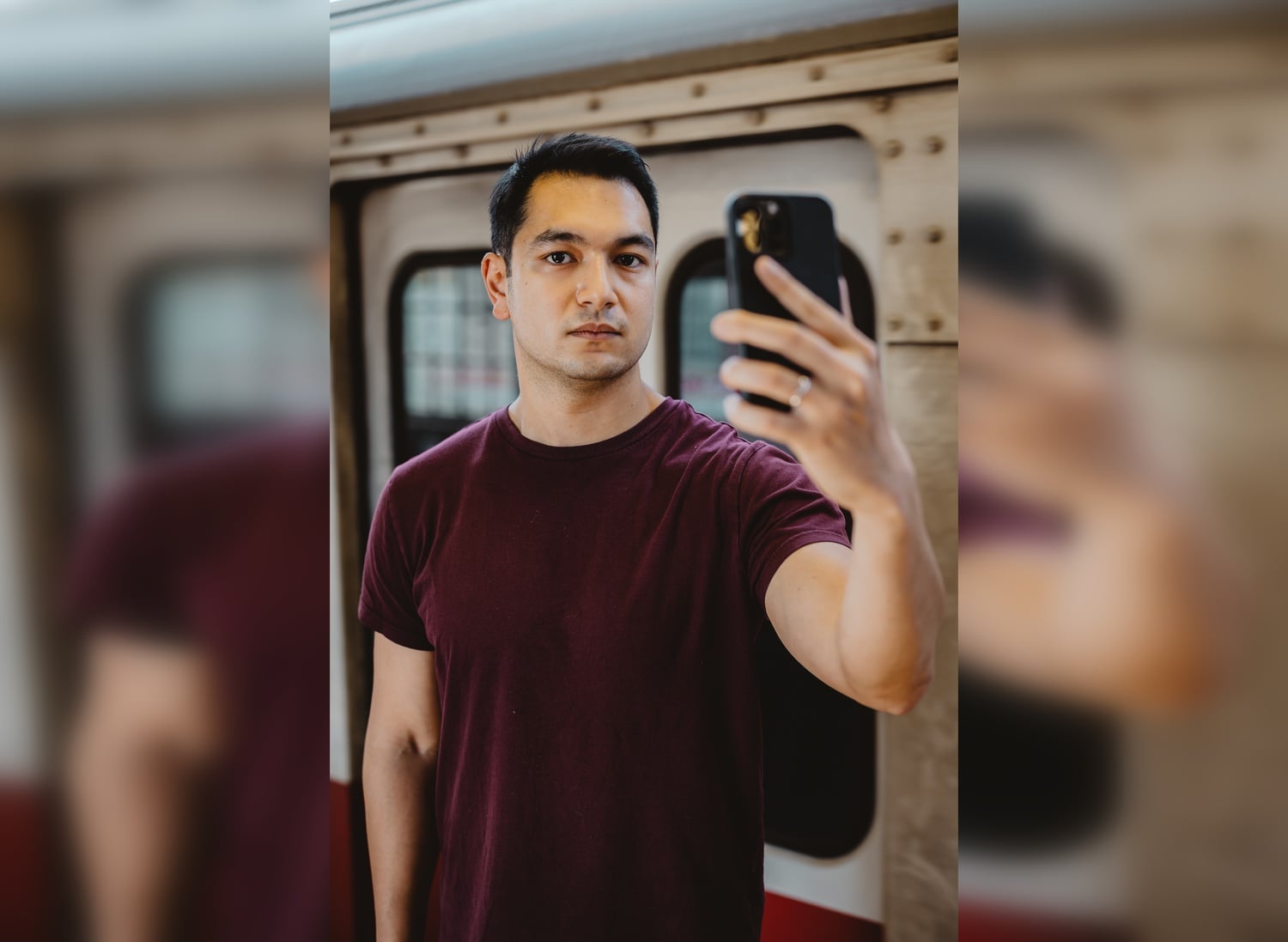 Headshot photo of Jed Paul holding his phone.