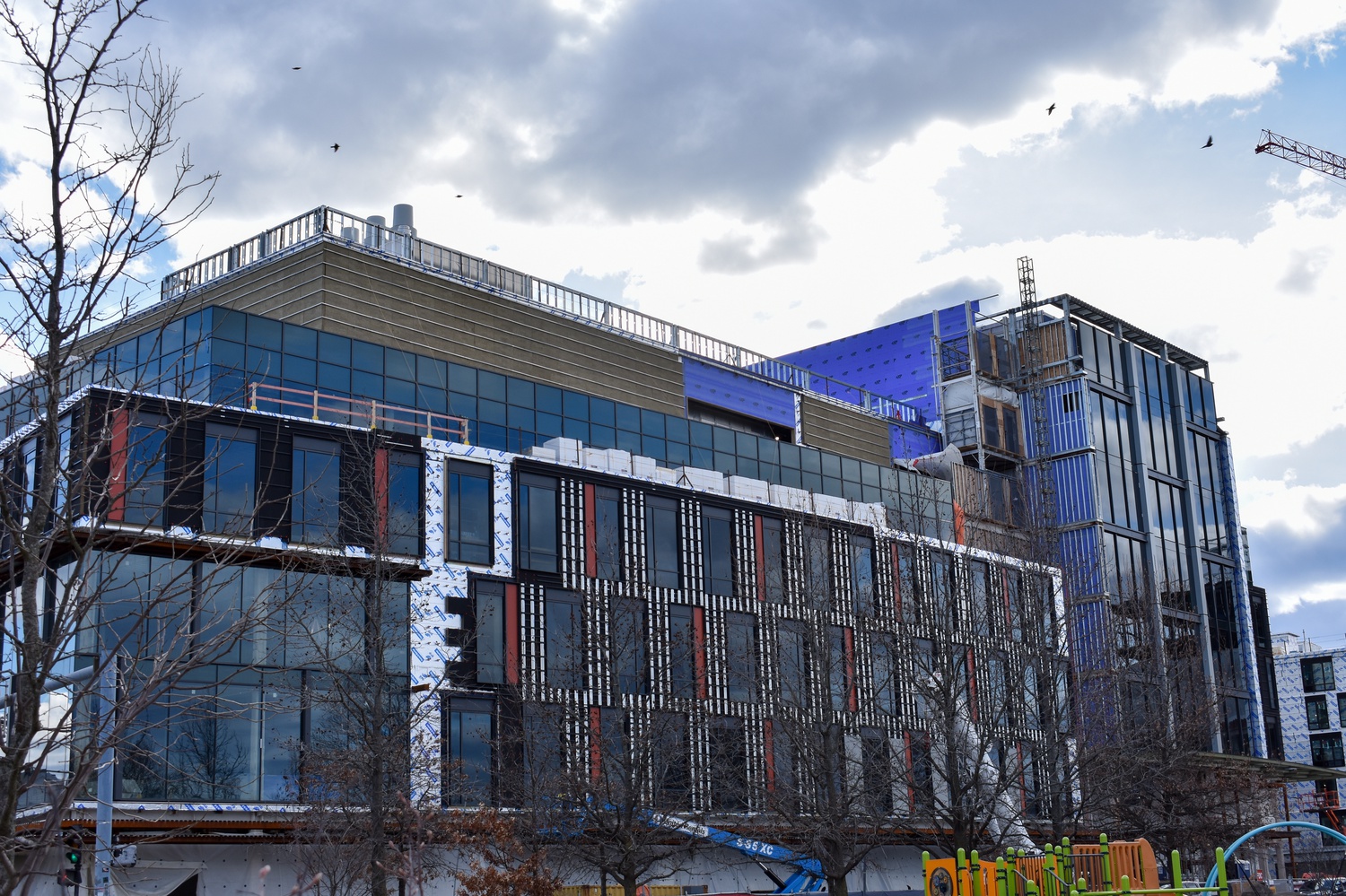 250, the first of the three Allston Labworks buildings, nears completion across the street from a park.