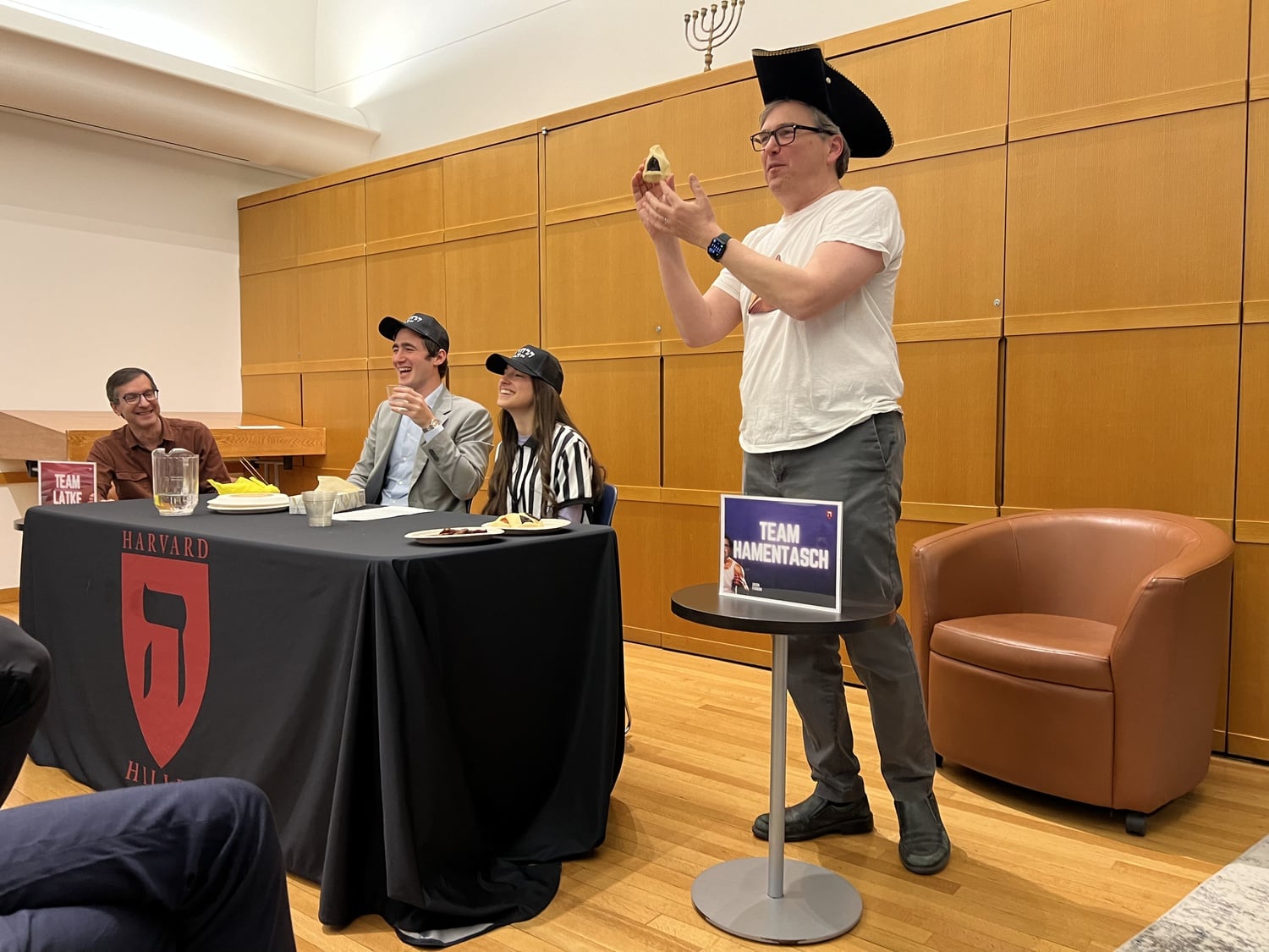 Economics professor Jason Furman '92 holds a hamentasch at a comical Hillel event where he debated with his Economics 10 co-teacher David I. Laibson '88 about whether hamentaschen or latkes are the superior Jewish holiday food.
