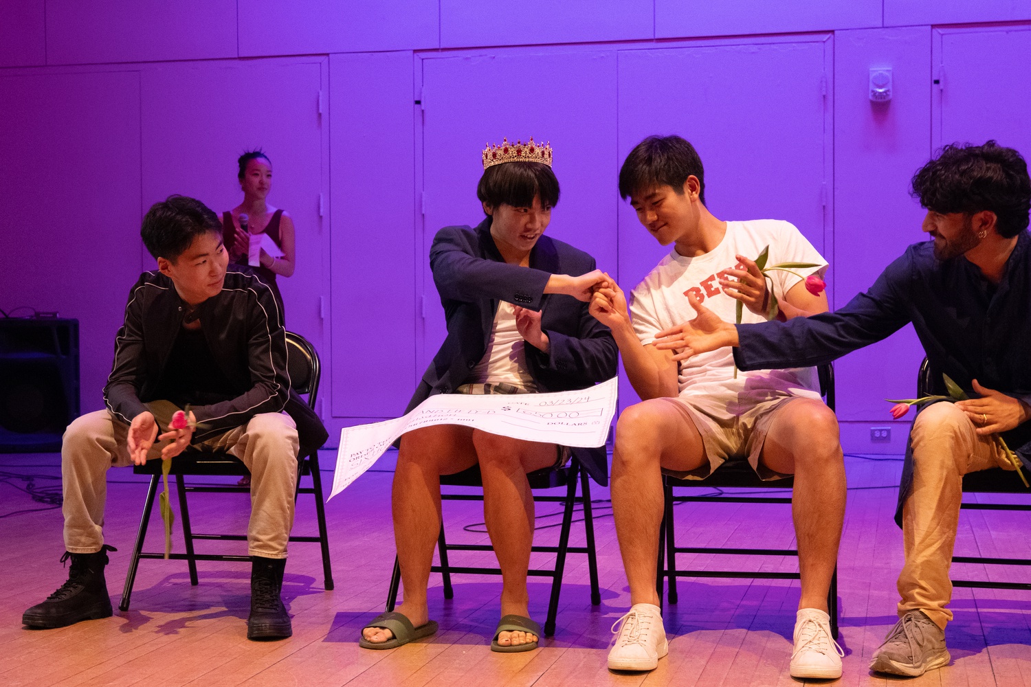 Matthew M. Vu '27 receives a large $650 check for winning the Mr. Asian Sensation pageant. Vu said he will donate the money to Children of Vietnam.
