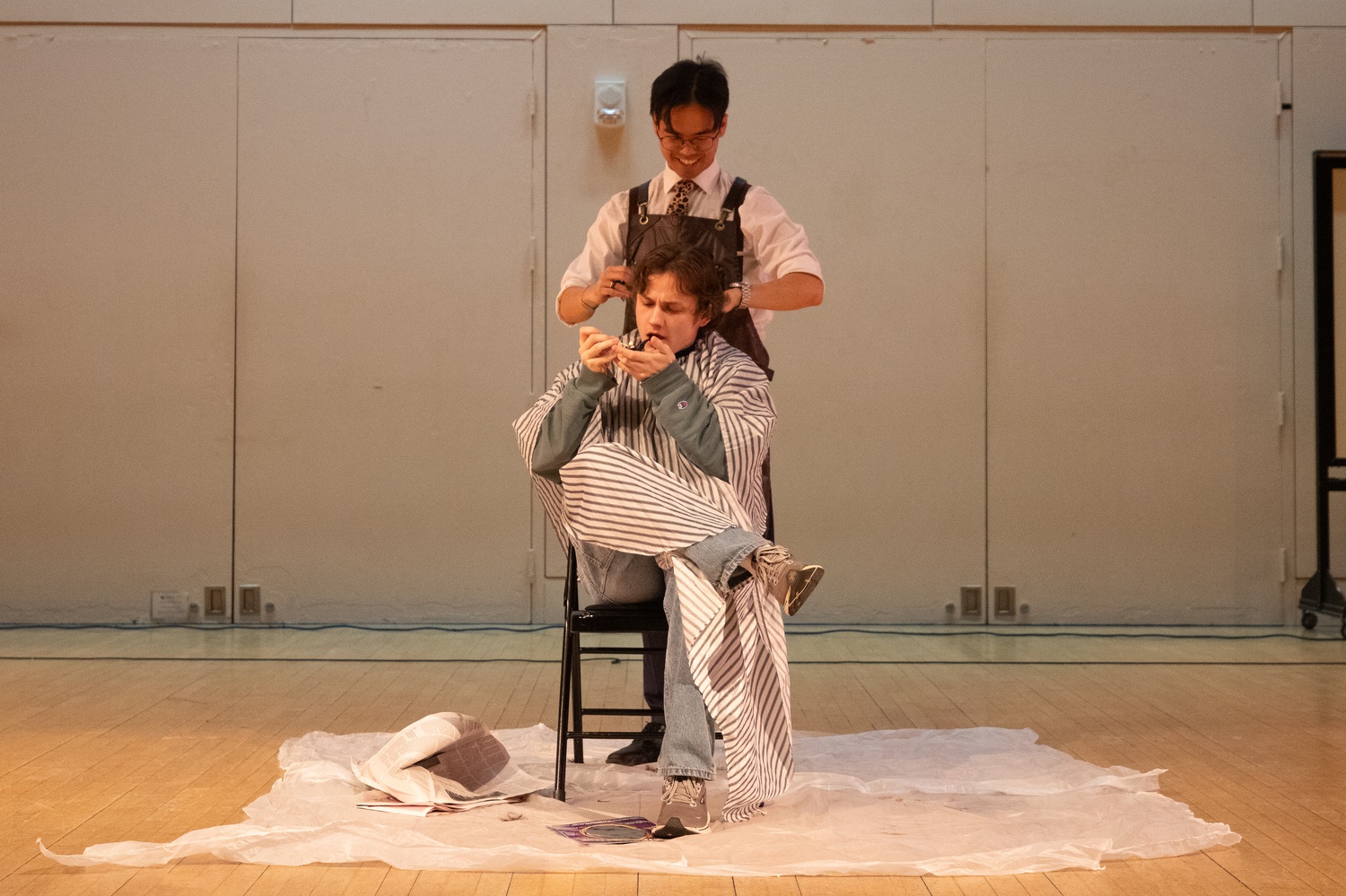Aaron J. Kang '25 showcases his barber skills by giving an audience member a quick trim during the show. Kang founded a salon in his common room — "Kang's Cuts" — during his freshman year.