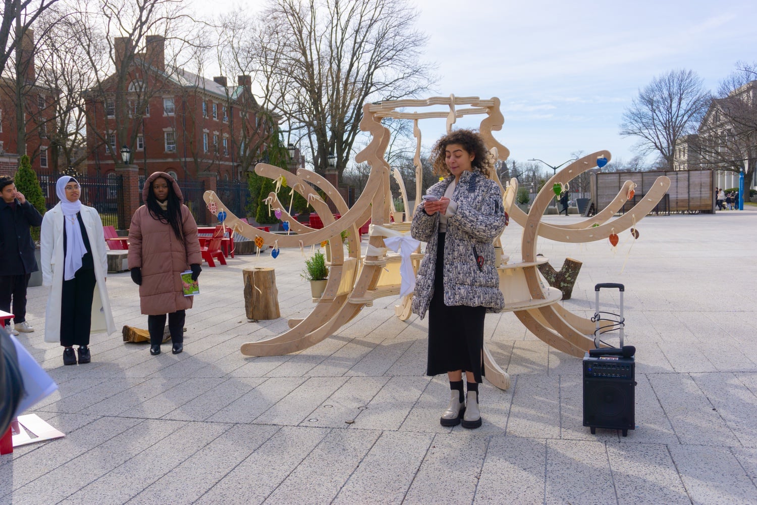 Women's Center intern Jana Amin '25 speaks to attendees at the unveiling of the Women's Week 2024 sculpture, while intern Nabila Chowdhury '25 stands to the side with Associate Dean of Students for Inclusion and Belonging Alta T. Mauro.