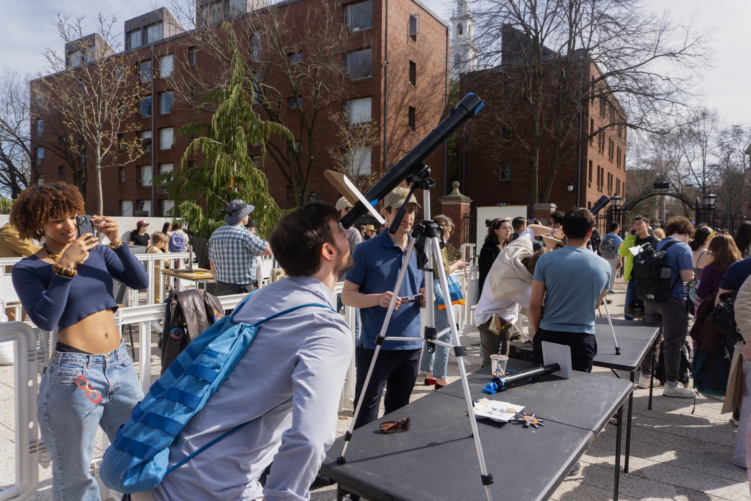 Eclipse watchers look through telescopes set up by Student Astronomers at Harvard-Radcliffe on the Science Center Plaza.