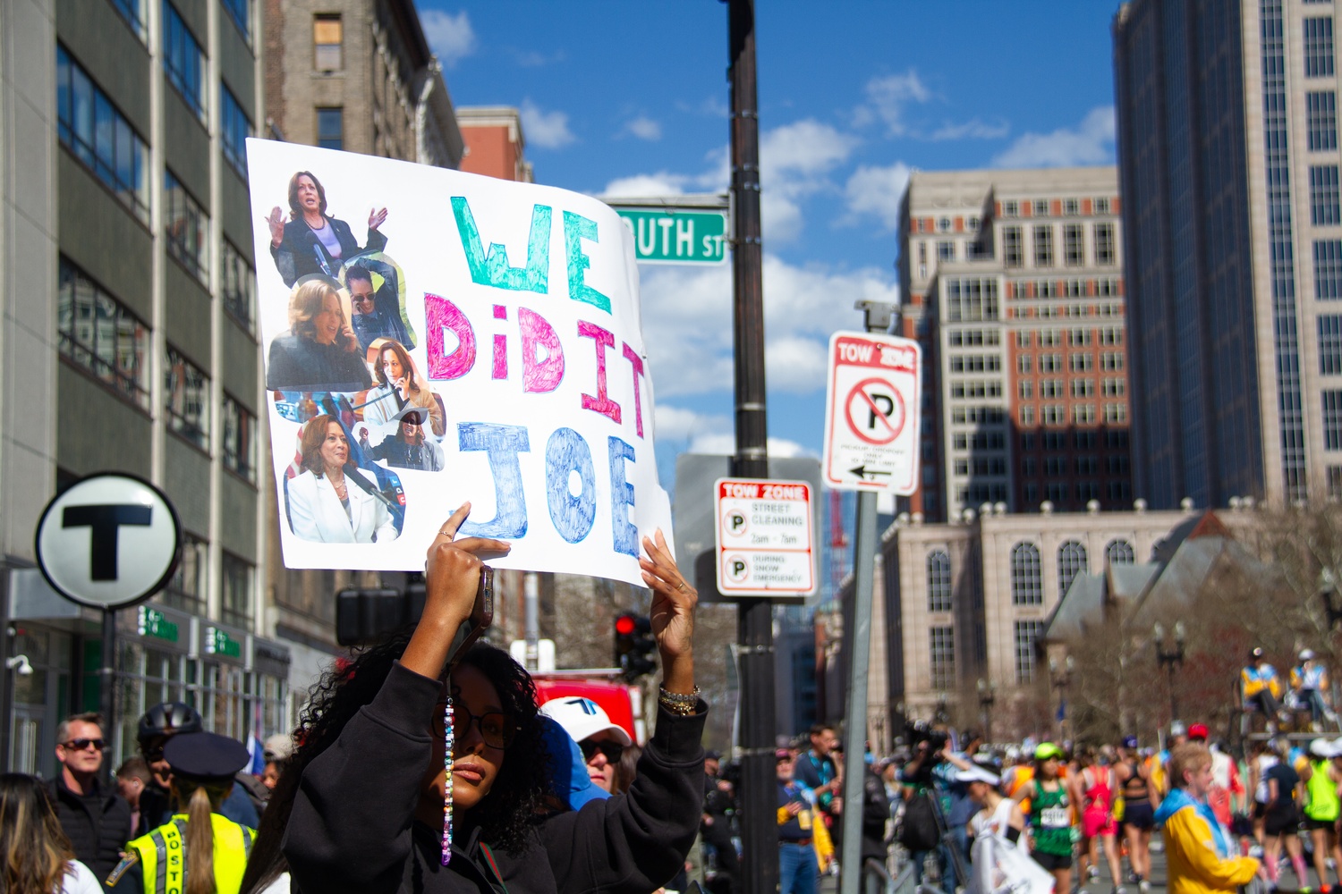 A spectator holds a sign saying "We did it, Joe" from the sidelines of the race.