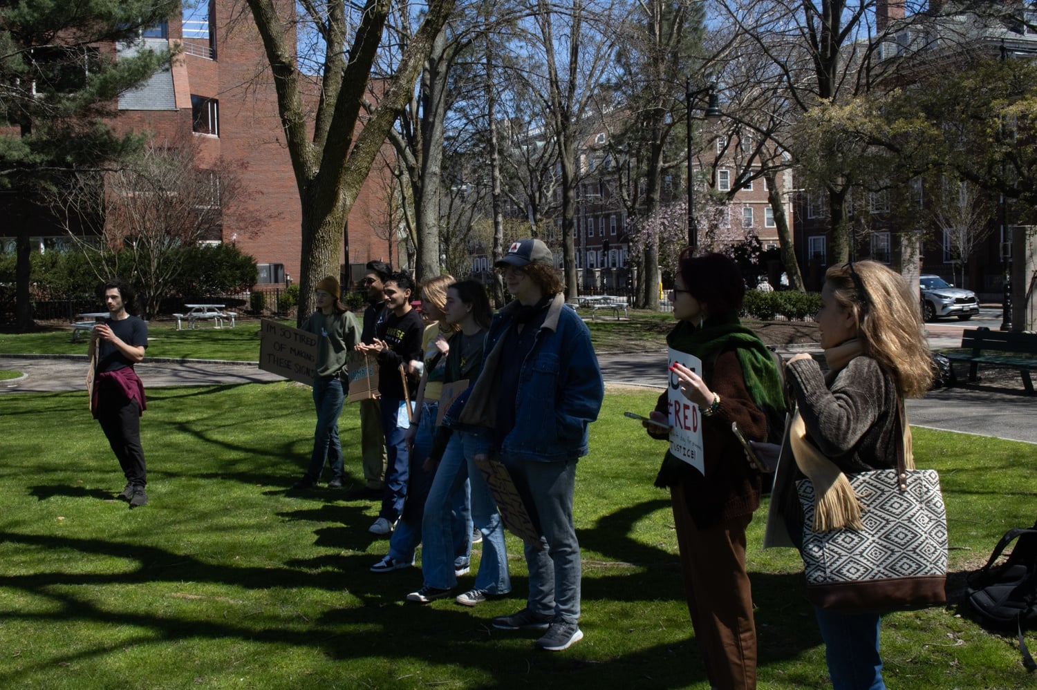 A group of protestors gather at JFK Park outside the Harvard Kennedy School to protest actions and affiliations by the University they said were anti-environmental.