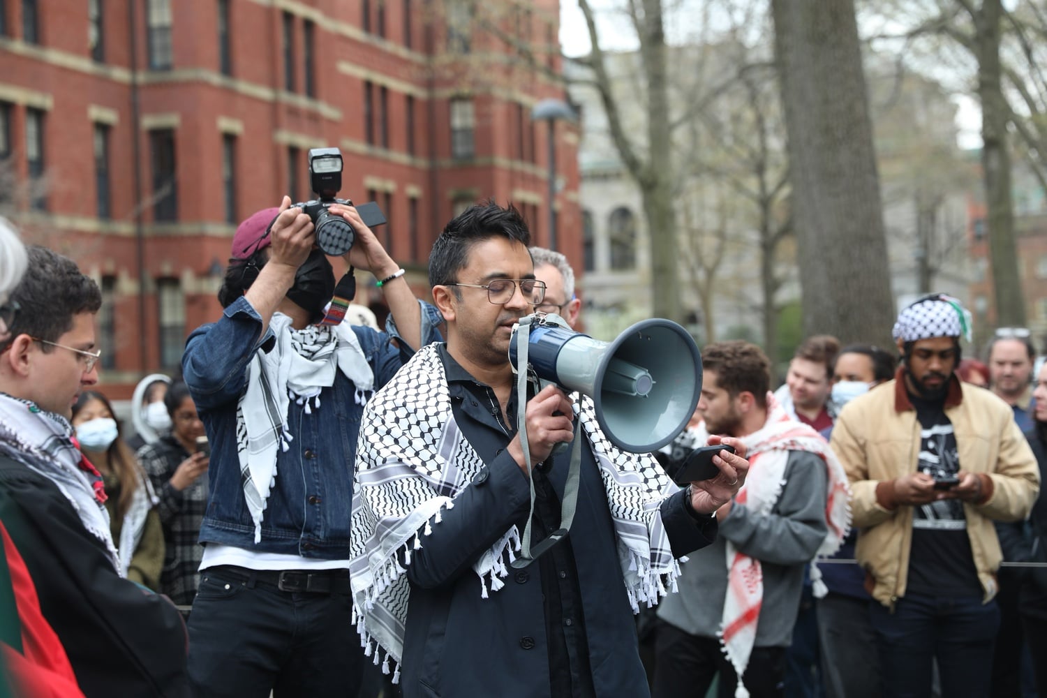 Harvard professor of the arts Vijay Iyer stands with a bullhorn at near the encampment. Iyer delivered a statement on behalf of Harvard Faculty and Staff for Justice in Palestine Wendesday afternoon.
