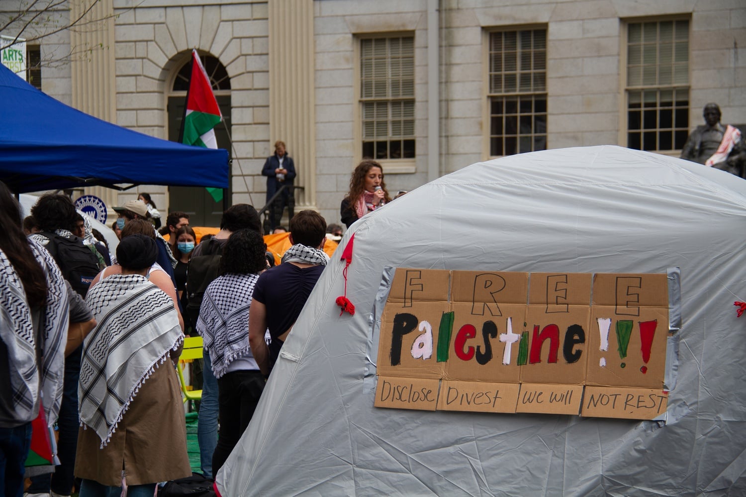 A tent at the Harvard Yard encampment bears a sign reading "Free Palestine" and "Disclose, Divest, We Will Not Rest."