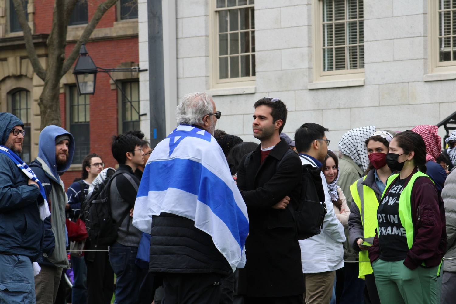 A counterprotester wearing an Israeli flag addresses protesters in front of University Hall Wednesday afternoon.