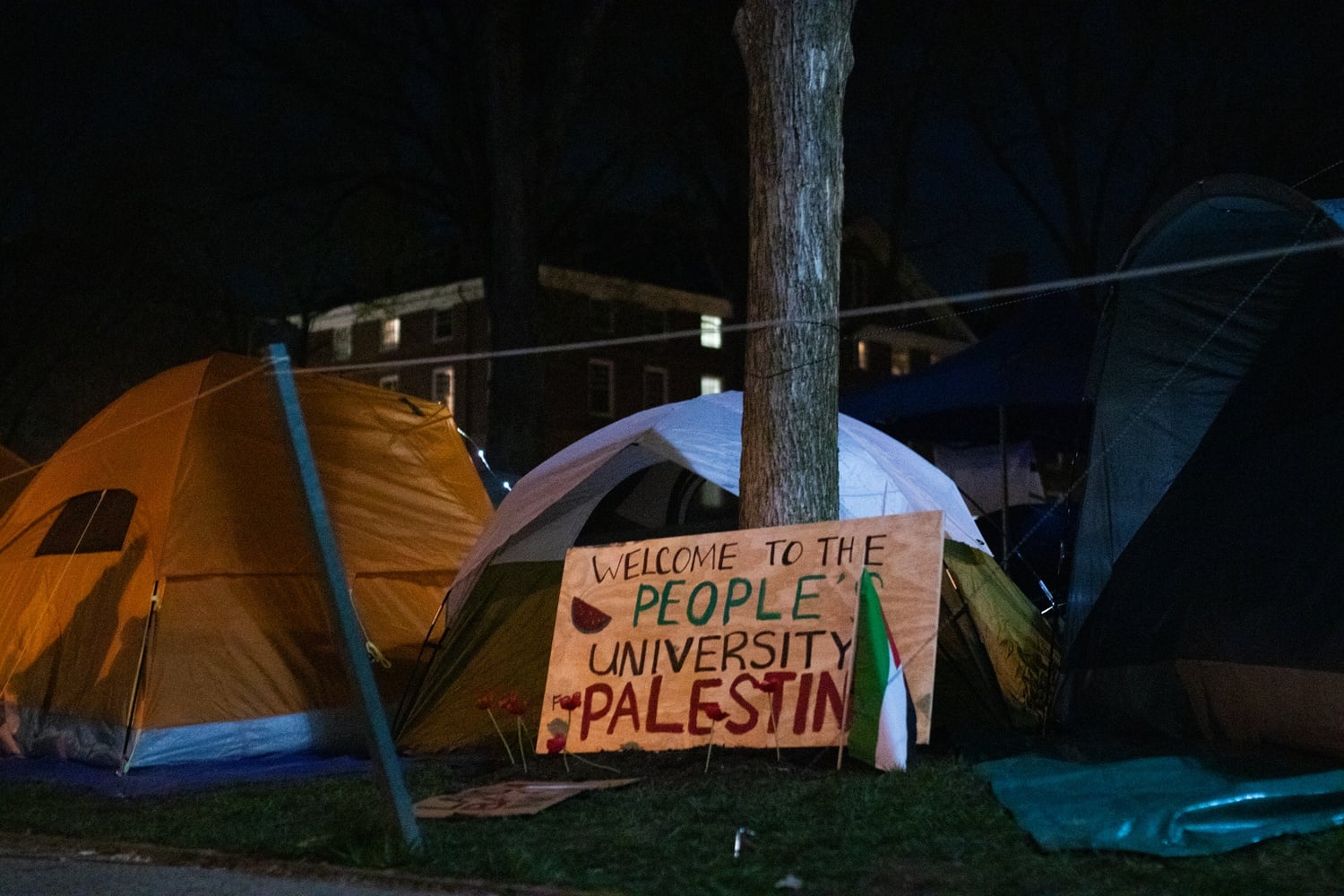 Past midnight, encampment protesters settle into tents in front of University Hall. Small groups of protesters circle the encampment through the night as Harvard University Police Department vehicles make rounds.